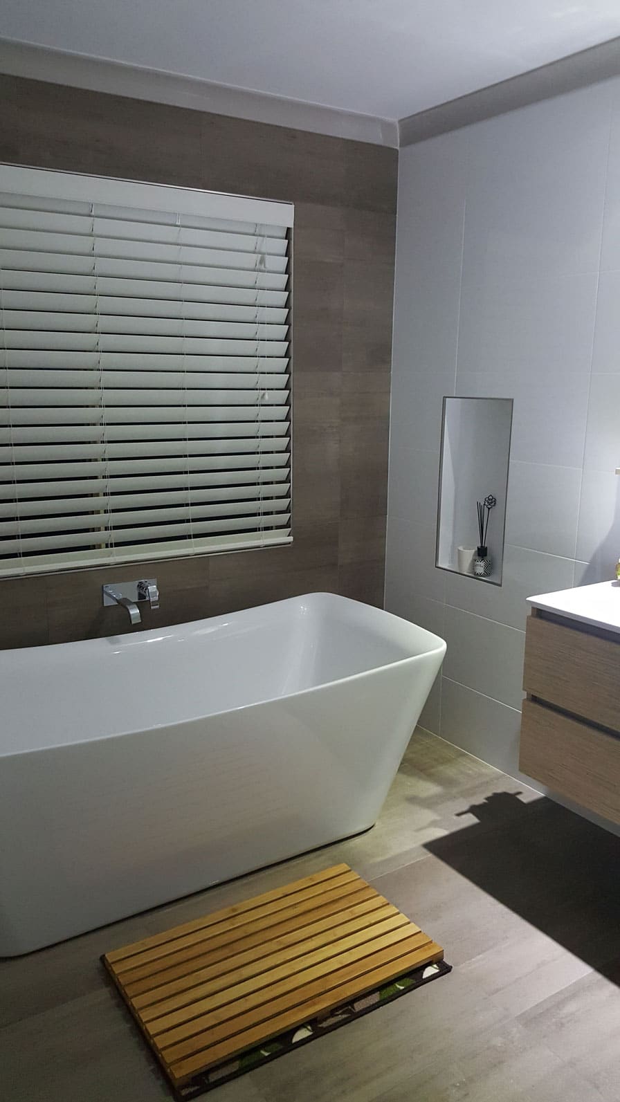 A small bathroom with brown wall tiles